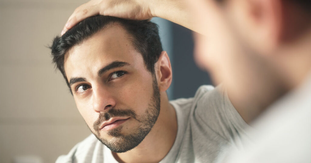 Man looking at his hairline
