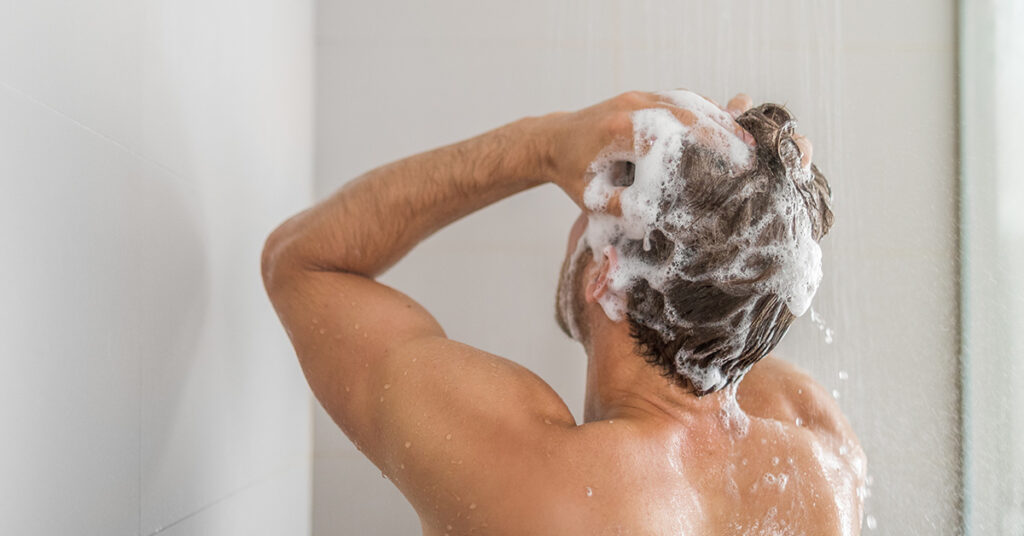 Man shampooing hair in the shoer.