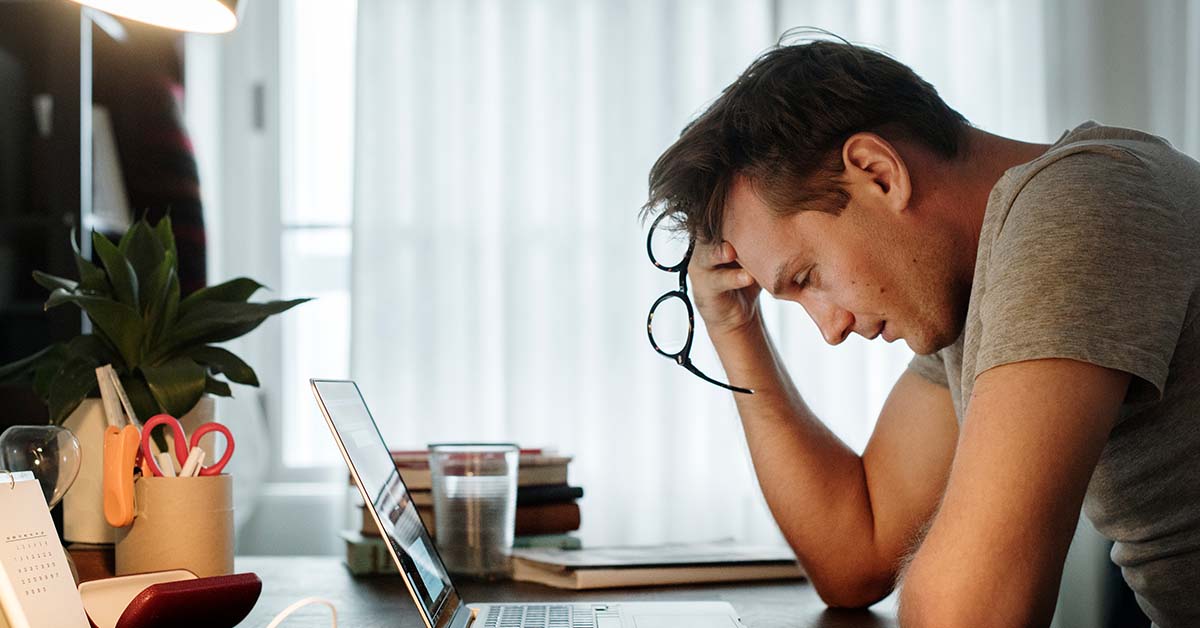 Man stressed out in front of laptop.