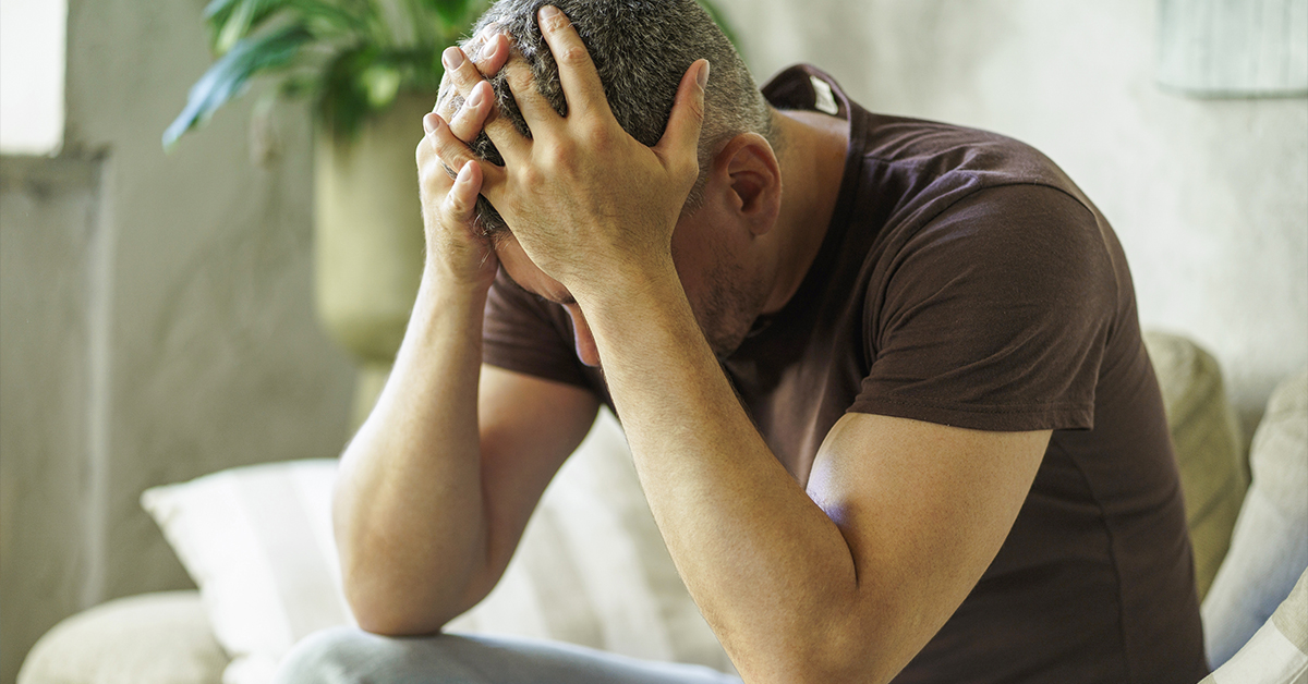 Stressed man with his head in his hands.