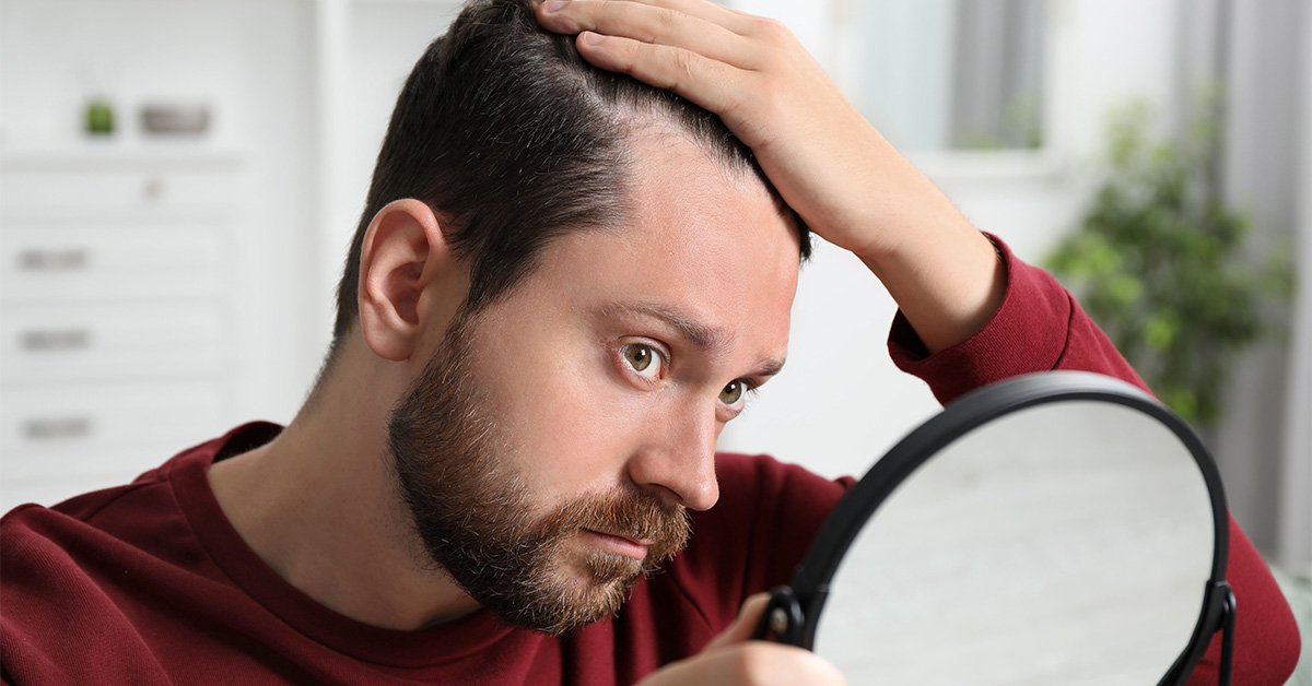 Man checking hairline in mirror