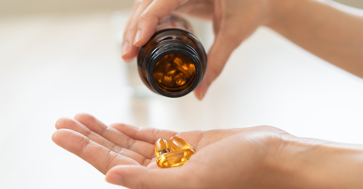 Pouring pills from a brown bottle into an open hand.