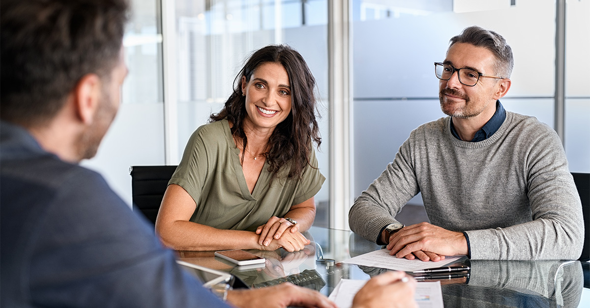 Couple having a conversation at a meeting table.